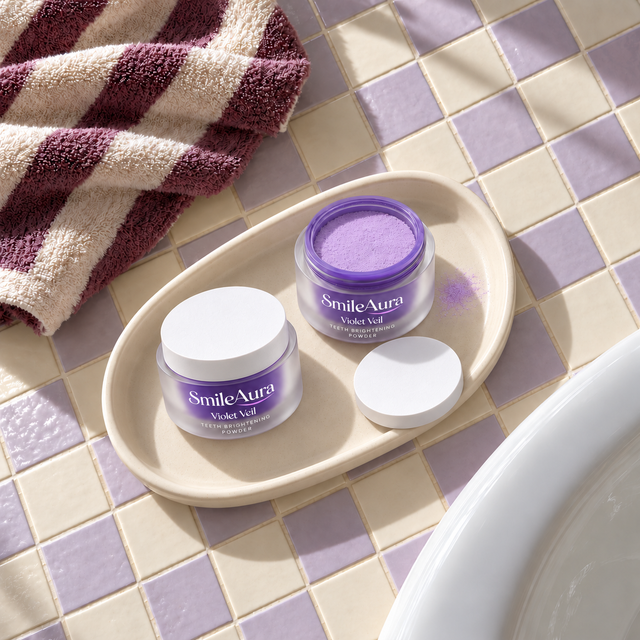 Overhead view of two SmileAura Violet Veil jars, one open, on an oval tray over cream and lilac tiles beside a striped towel.